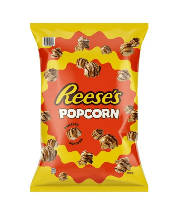 Front of a yellow bag of Reese’s Peanut Butter & Chocolate Drizzled Popcorn showing logo and delicious popcorn pieces (63.8g pack)