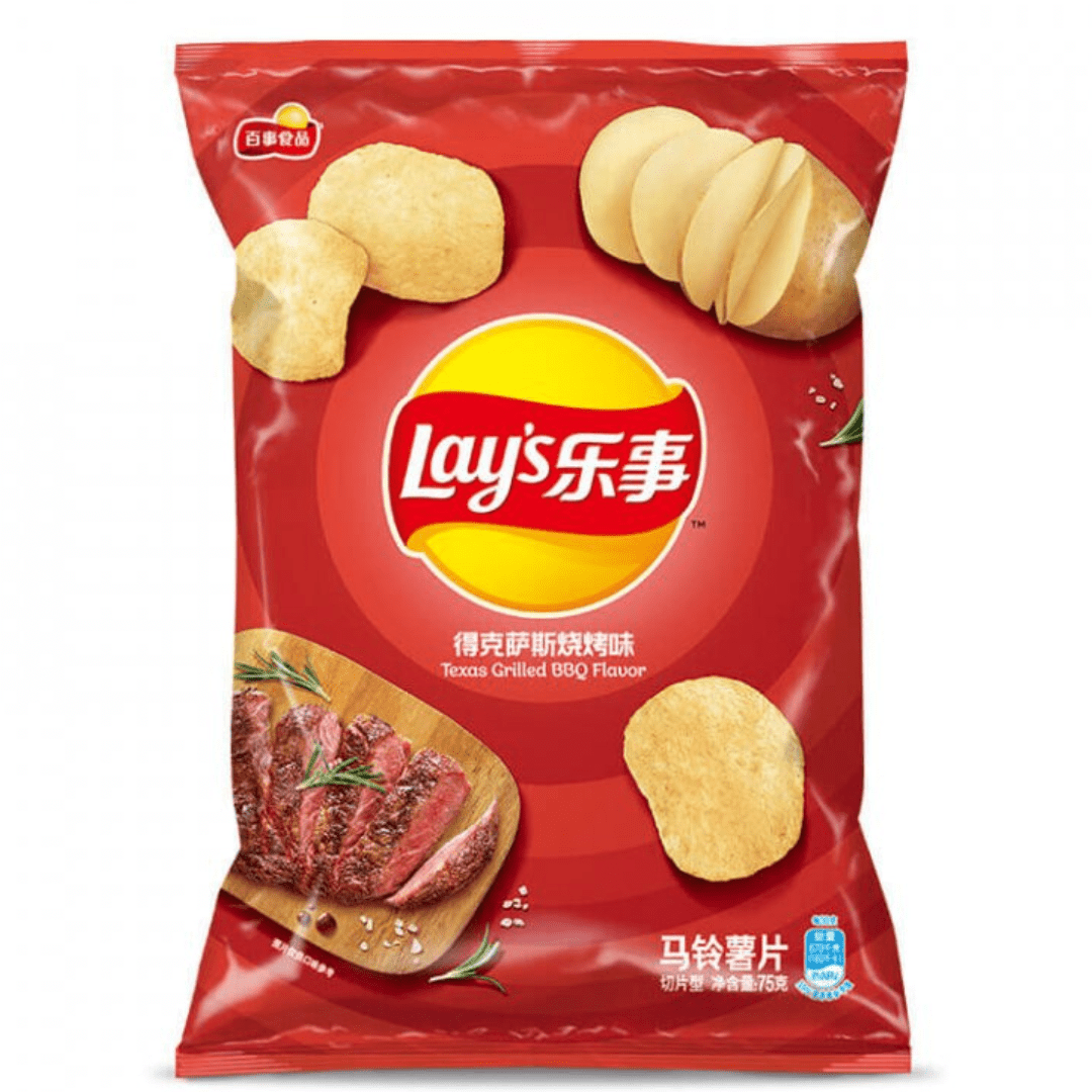 Front of Lay’s Texas Grilled BBQ bag featuring a red background, logo, BBQ flavour text, and images of chips and grilled meat (70g pack)