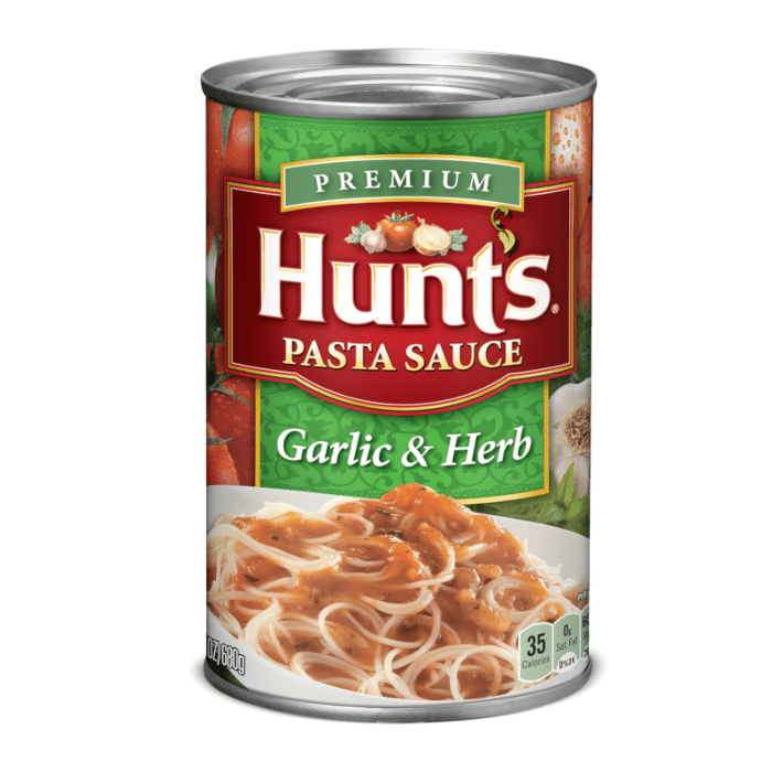 Front of Hunts Pasta Sauce Garlic & Herb can displaying rich green and red colours, featuring garlic and herb imagery and serving suggestion with pasta (680g pack)