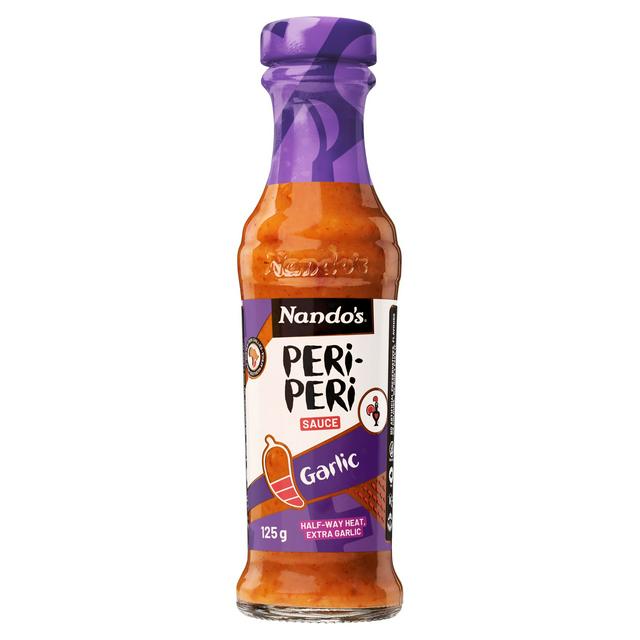 Front of Nando's Garlic Medium Sauce bottle showing vibrant label with garlic and medium heat indicator, featuring 250g pack size.