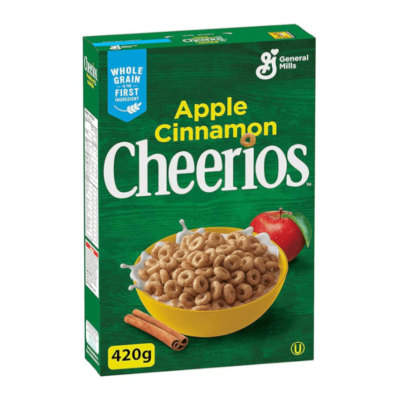 Front of General Mills Apple Cinnamon Cheerios box featuring a green background, logo, apple and cinnamon illustrations, and a yellow bowl filled with cereal (420g pack)