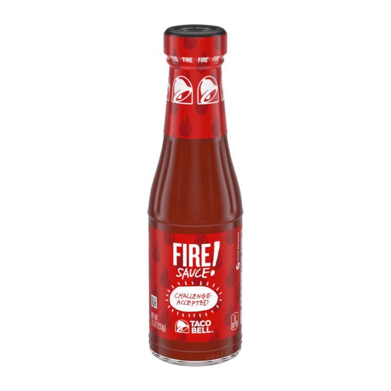 Front of Taco Bell FIRE Hot Sauce bottle showing bold red logo, fiery design elements, and 'Challenge Accepted' label (213g pack)